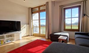 a living room with a flat screen tv and a couch at Ferienwohnung Golfblick in Wittenbeck