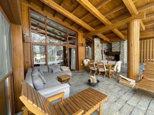 ein Wohnzimmer mit einem Sofa und einem Tisch in der Unterkunft Pirin Golf and Spa Luxury Chalet in Bansko