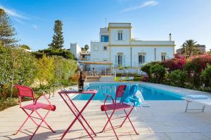 a group of chairs and a table next to a pool at Il Giardino Ritrovato in Marsala