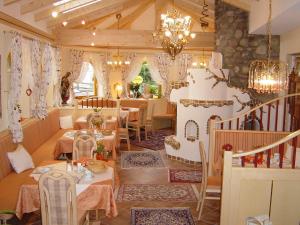 a restaurant with tables and chairs and a chandelier at Pension & Appartement Steinwender in Bad Kleinkirchheim