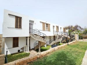 biały budynek ze schodami i dziedzińcem w obiekcie HOLIDAYS BEACH & POOL ,AIRCOND , Las Americas w Aronie