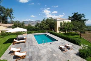 a swimming pool with chairs and an umbrella at Nerello Mascalese in Montelaguardia