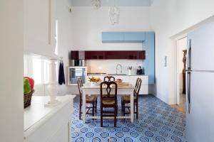 a kitchen with a table and chairs and a refrigerator at Il Giardino Ritrovato in Marsala