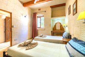 a bedroom with two beds and a mirror at Ta Guljetta 4 bedroom Villa with private pool in Marsalforn