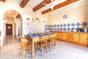 una grande cucina con tavolo e sedie in legno di Ta Guljetta 4 bedroom Villa with private pool a Marsalforn