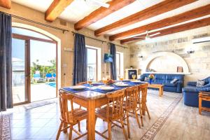 ein großes Esszimmer mit einem Tisch und Stühlen in der Unterkunft Ta Guljetta 4 bedroom Villa with private pool in Marsalforn