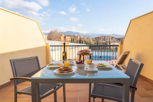 una mesa con platos de comida en el balcón en Hotel Macià Monasterio de los Basilios, en Granada
