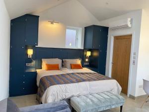 a blue bedroom with a large bed with orange pillows at Tiny home, the Wye Valley, Clanna Cottage Llandogo in Llandogo