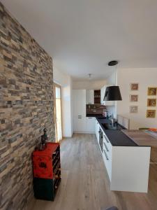 a kitchen with a brick wall and a counter top at La bougainville - luxury apartment in Nago-Torbole