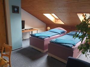 2 Betten in einem Zimmer mit einem Tisch und einem Schreibtisch in der Unterkunft Pension Beránek in Prag