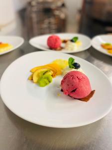 une assiette blanche avec une crème glacée rose sur elle dans l'établissement Hotel Restaurant Heidihof, à Maienfeld