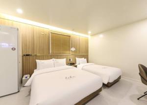 twee bedden in een hotelkamer met bij Like Hotel in Gwangju