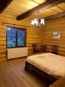 ein Schlafzimmer mit einem Bett in einem Holzzimmer in der Unterkunft Chalet Poligon in Vatra Dornei