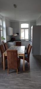 een keuken met een tafel en stoelen in een kamer bij FeWo Droyßig Villa Edelgard in Droyßig