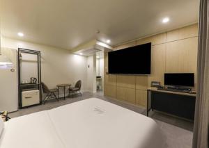 een hotelkamer met een bed en een flatscreen-tv bij Like Hotel in Gwangju
