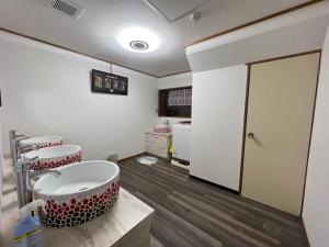 baño con bañera grande y lavamanos en フクロウの御宿　新館, en Fuefuki