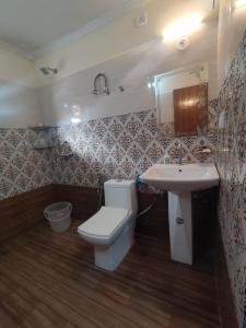 a bathroom with a toilet and a sink at Four Season Homestay Bhowali Bhimtal in Bhowāli