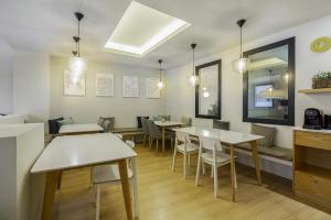 a dining room with white tables and chairs at Ola Living Hostal Diagonal in Barcelona