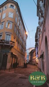 an empty street in a city with buildings at La Vie de Bohème in Trieste