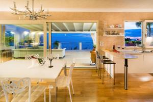 a kitchen and dining room with a table and chairs at Villa Luce in Letojanni