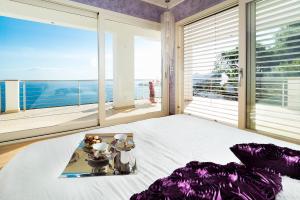 a bedroom with a bed with a view of the ocean at Villa Luce in Letojanni