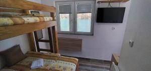 a room with two bunk beds and a flat screen tv at Apartman na Drini in Foča