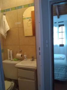 een badkamer met een wastafel, een toilet en een spiegel bij A Alquiler temporario Arrullo de Luna in Yerba Buena