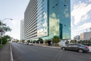 une voiture garée devant un grand bâtiment dans l'établissement Flat vision, à Brasilia