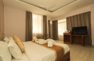 Hotel Buddha's Abode في دارامشالا: غرفه فندقيه سرير وتلفزيون