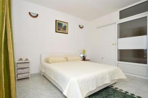 een witte slaapkamer met een bed en een groot raam bij Apartments Nina in Rogoznica