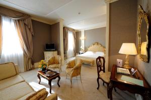una camera d'albergo con letto e soggiorno di Ca' Sagredo Hotel a Venezia