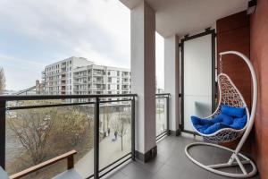 a balcony with a rattan chair and a view of a building at Ursynów Geometric Homey Apartment in Warsaw