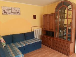 a living room with a blue couch and a cabinet at Appartamento Cascate delle Marmore in Le Marmore
