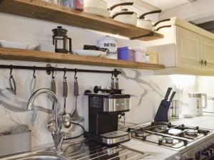 a kitchen with a sink and a stove top oven at Weavers Cottage in Holmfirth