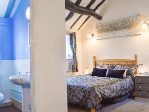 a bedroom with a bed and a sink at Weavers Cottage in Holmfirth