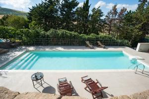 a swimming pool with four chairs and a table at Baglio Maranzano - Titi in Buseto Palizzolo