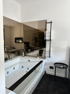 a bathroom with a tub and a large mirror at Vulkan lux in Zemun