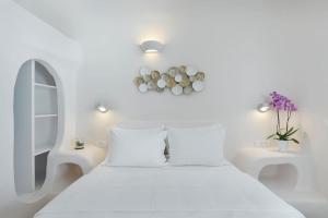 a white bedroom with a white bed and two tables at Aleanna Traditional Villa Fira in Fira