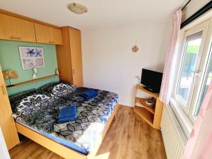 a bedroom with a bed and a window at De Parel van Zeeland met jacuzzi en sauna in Sint Annaland