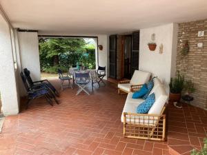 eine Terrasse mit Sofas, einem Tisch und Stühlen in der Unterkunft Appartamento La Betulla in San Giovanni in Marignano