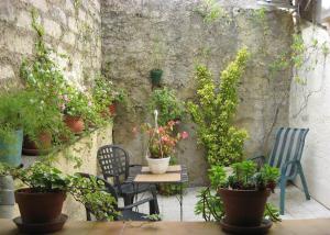 ペズナにあるTerrasse fleurieのパティオ(椅子、鉢植えの植物が置かれたテーブル付)