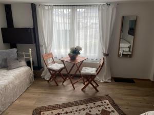 a living room with a table and chairs and a window at Haus Bohle in Dornbirn