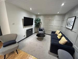 a living room with a couch and a tv at Bentinck Residence by Sasco Apartments, Lytham St Annes in Lytham St Annes