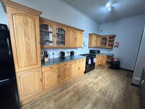 a kitchen with wooden cabinets and black appliances at Bentinck Residence by Sasco Apartments, Lytham St Annes in Lytham St Annes