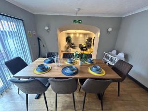 a dining room with a wooden table and chairs at Bentinck Residence by Sasco Apartments, Lytham St Annes in Lytham St Annes