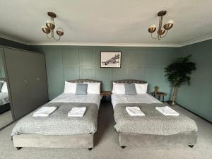a bedroom with two beds with towels on them at Bentinck Residence by Sasco Apartments, Lytham St Annes in Lytham St Annes