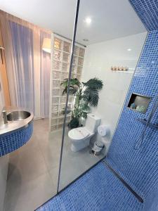 a bathroom with a toilet and a shower with blue tiles at Hostal Fornet Altea in Altea