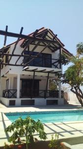 una casa con piscina frente a ella en Cabaña Recinto del Pensar, en Santa Marta