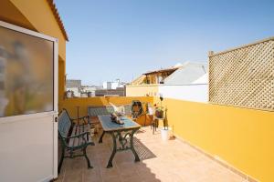 a balcony with a table and chairs on a yellow wall at Casa Las Caracolas in Castillo del Romeral