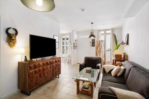 a living room with a couch and a flat screen tv at Casa Las Caracolas in Castillo del Romeral